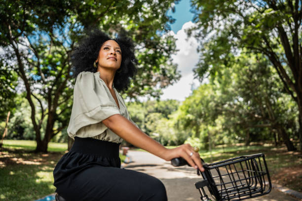 Young woman on bicycle contemplating at public park
