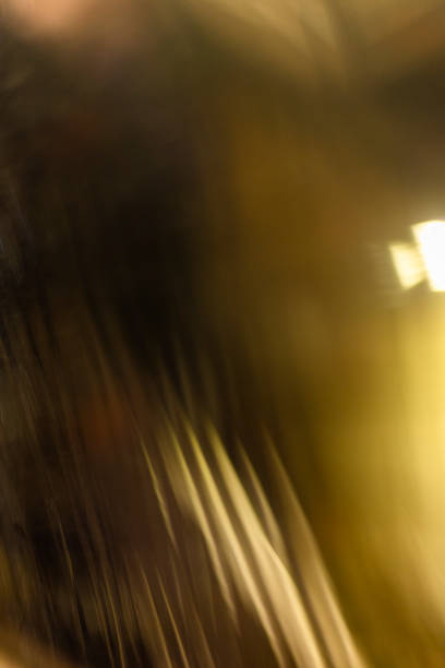 The street lights, ethereal smudges against the darkness, are further obscured by the rain-streaked window, creating a dreamlike atmosphere.