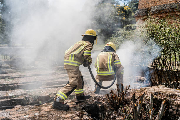 istock Firefighters using hose to put out fire outdoors 1999982970