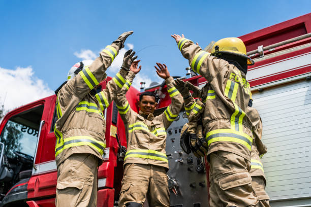 istock Firefighters celebrating with arms raised outdoors 1999984423