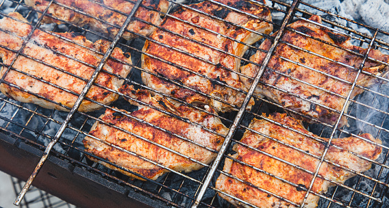 Barbecue with tasty grilled meat on grill, closeup. Barbeque party.