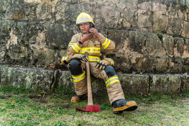 Young fireman taking off helmet outdoors