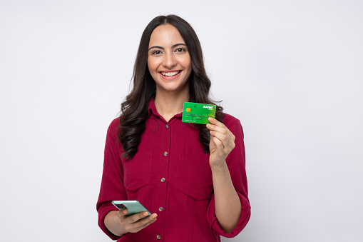 Photo of charming positive girl wear shirt holding plastic card phone buying online isolated on white background