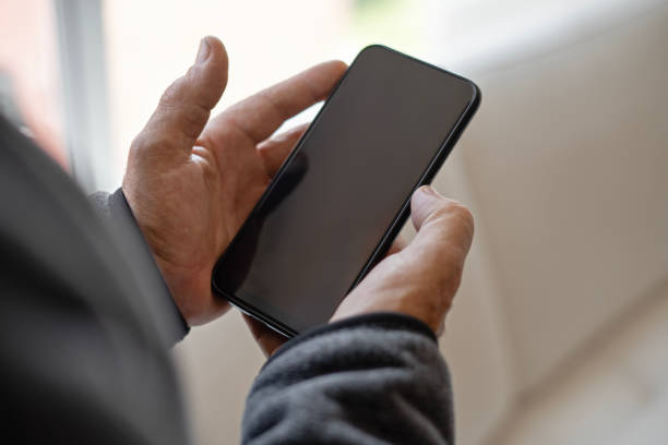 istock Close-up of older man's hands using smartphone at home. 2000079669
