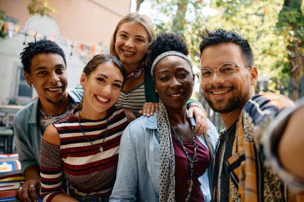 istock Multiracial group of friends having fun while taking selfie in a cafe and looking at camera. 2000109506