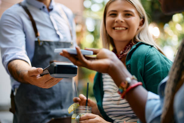 istock Close up of female cafe guest using smart phone while making a payment. 2000111795
