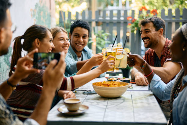 istock Young cheerful friends toasting with drinks while gathering in a cafe, 2000113958