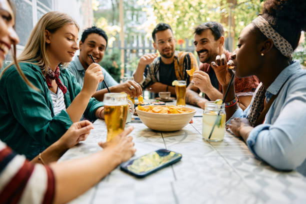 istock Group of young happy friends enjoying while gathering in cafe. 2000115057