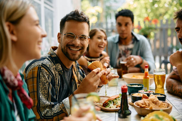 istock Young man having fun while having a lunch with friends in a restaurant. 2000117162