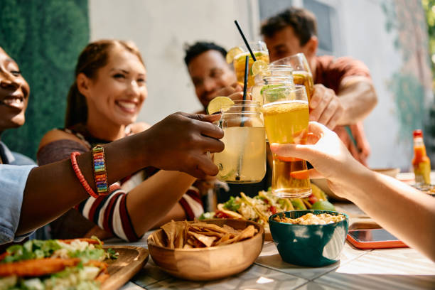 istock Close up of friends toasting with drinks while gathering in a restaurant. 2000120407