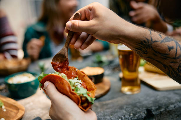 istock Close up of man having tacos while eating in Mexican restaurant. 2000123609