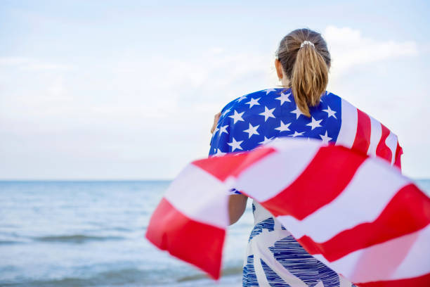 istock Woman Draped in American Flag at the Beach 2000199614