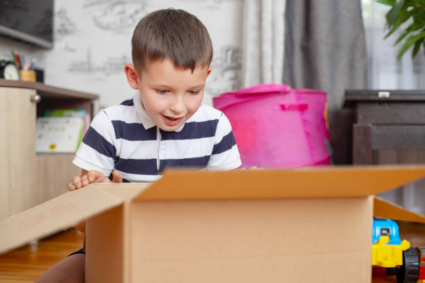 Young Boy Excited by Surprise in Cardboard Box