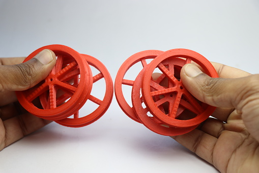 Wheels made using 3d printer and printed with PLA material for practical use. Set of 3d printed wheels held in the hand