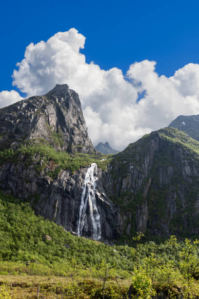istock Bright summer light shines on Valefossen waterfall, framed by the steep cliffs and vibrant greenery of the Lofoten Islands, Norway. 2000224090