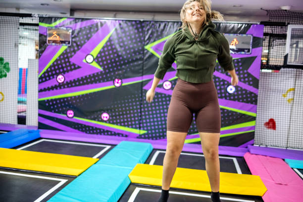 Two young women enjoying exercising on playground with trampolines