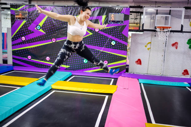 Young woman enjoying exercising on playground full with trampolines