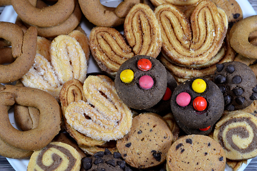 Assorted baked cookies and biscuits of cinnamon biscuits, baked round biscuits that are hard, flat and crispy, chocolate butter cookies and palmier, short for feuille de palmier, French cookies, selective focus