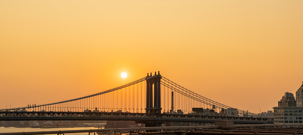 Manhattan Bridge at sunrise and some disc of the rising sun.
