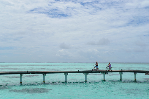 Maldives - September 18, 2023: People ride bicycles on the bridge on the Maldives island.