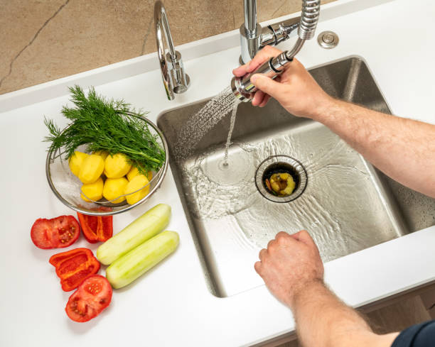 istock A man washes food waste into a dispenser 2000320868
