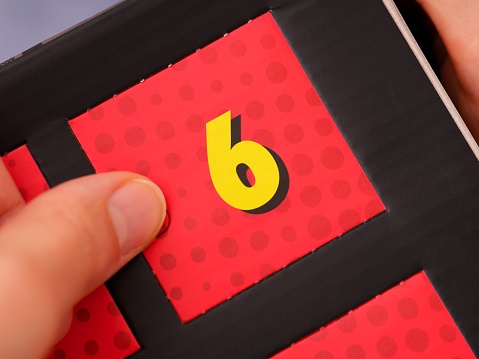 A woman hand opening a door with number 6 on an advent calendar.