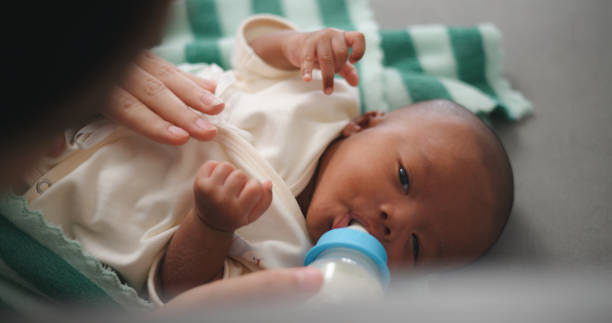 istock Young Asian mother feeding her newborn baby with a bottle 2000343899