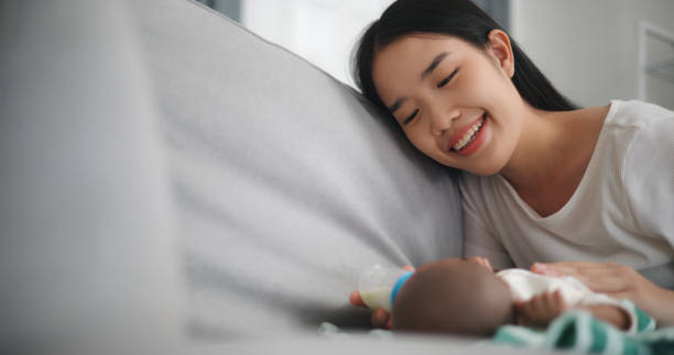 istock Young Asian mother feeding her newborn baby with a bottle 2000345497
