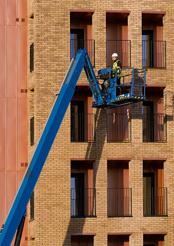 Glasgow, UK, January 13th 2024, Scissor lift being operated by construction workmen for safe access at height