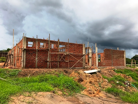 Photographic image of A house  building under construction under a stormy sky