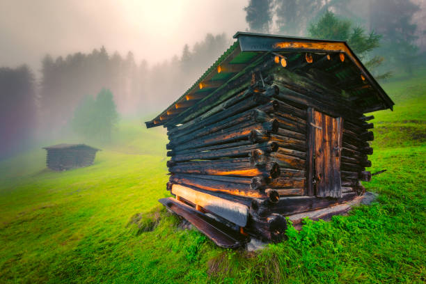An old barn on a foggy rainy day in the Austrian Alps countryside