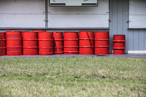 The red 55-gallon drums, lined up in rows, serve as vital containers for various industrial liquids
