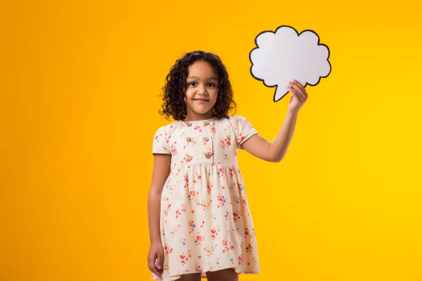 istock Smiling kid girl holding cloud bubble card. Dreaming concept 2000434812