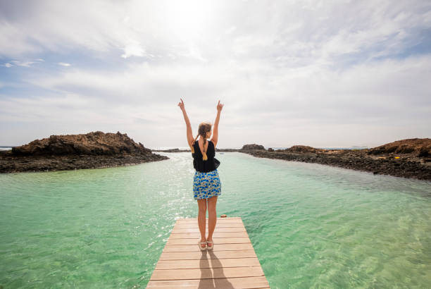istock Ocean Bliss: Woman with Arms Raised on a Wooden Boardwalk 2000448162