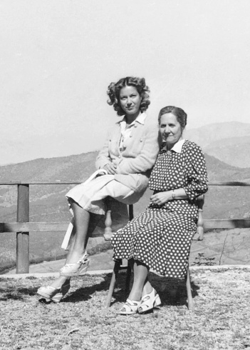 Mother and daughter sitting on a chair. 1941.