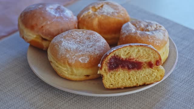 Sweet Delicious Traditional Polish Glazed Doughnut Paczek Filled with Sweet Jam Marmalade Prepared for Dessert on Fat Thursday Celebration before Ash Wednesday and Lent