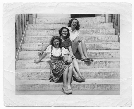 Group of young women sitting on a staircase. 1941.
