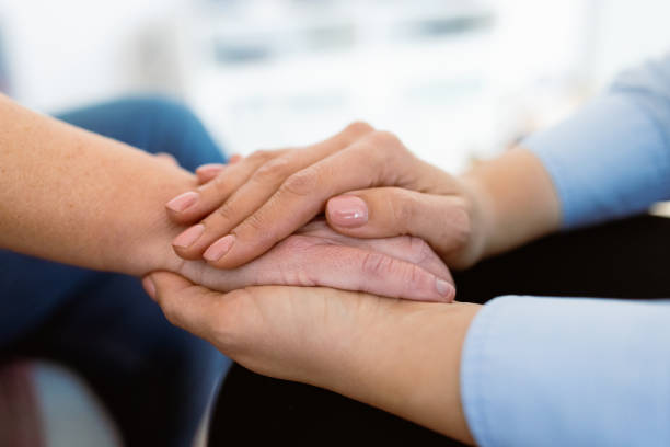 istock Close up of a doctors hands comforting oncology patient 2000471069