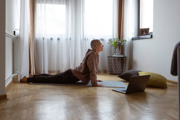 Living with cancer. Woman meditating with online coach stock photo