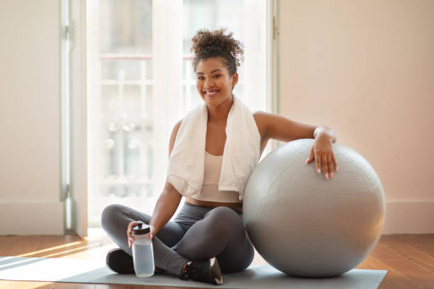 istock woman with towel takes hydration break after workout at home 2000480574