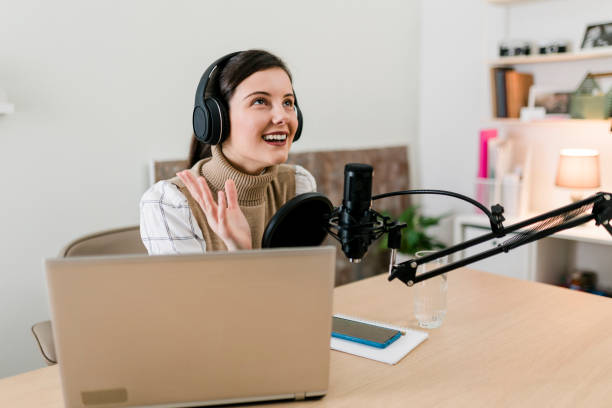 istock Young smiling women recording podcast and doing live streaming using microphone and headphones in recording studio 2000502929