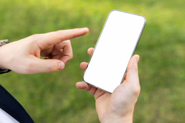 istock Close-up of a person's hands holding a smartphone with a blank white screen 2000530851