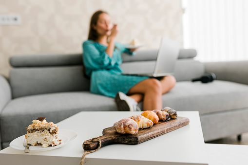 Close up of businesswoman working at home and eating snack