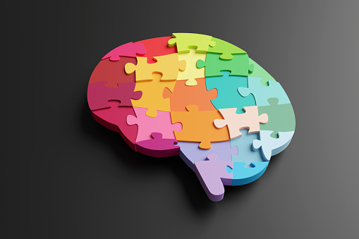 Multi-coloured jigsaw puzzles forming the shape of a brain on black background. Illustration of the concept of intelligence, wisdom, ideas and creativity