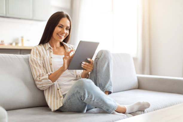 istock Beautiful young caucasian woman using digital tablet at home 2000547778