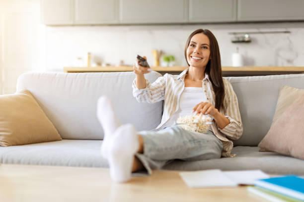 istock Lazy Day. Happy Young Woman Relaxing On Couch With Popcorn 2000548357