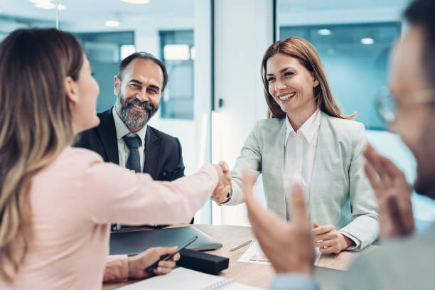istock Two smiling businesswomen shaking hands across the table 2000555658