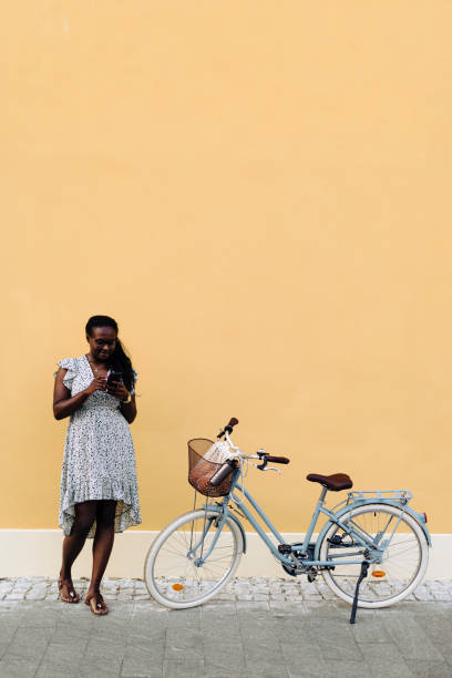istock Woman using her smart phone while standing near her bicycle 2000560508
