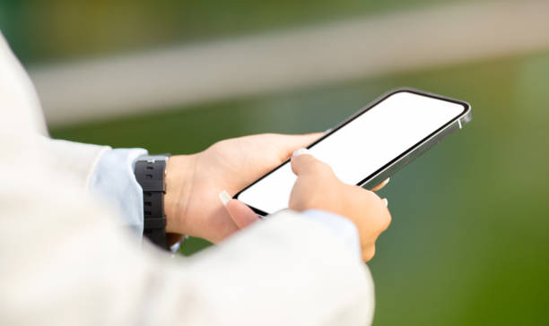 istock Close-up of a professional's hands using a modern smartphone, with a focus on the screen 2000562154
