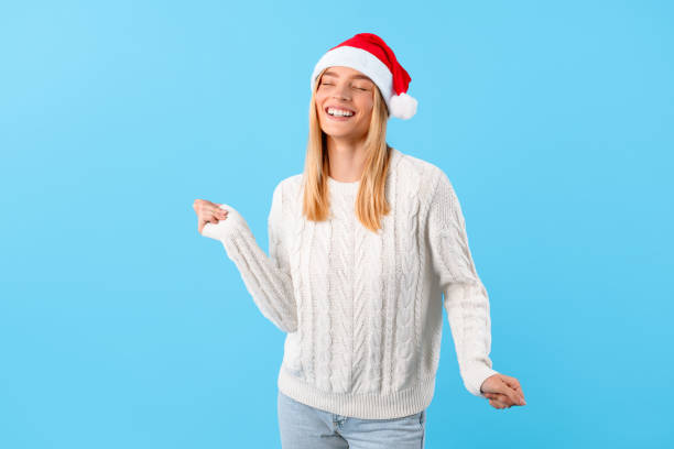 istock Joyful woman with Santa hat laughing and dancing 2000596159